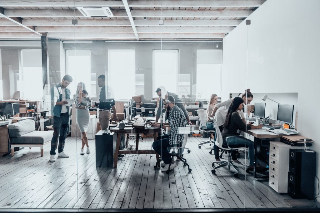 Enterprise employees working in an open office and using AI in business