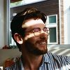 Profile photo of person smiling with sunlight on face.